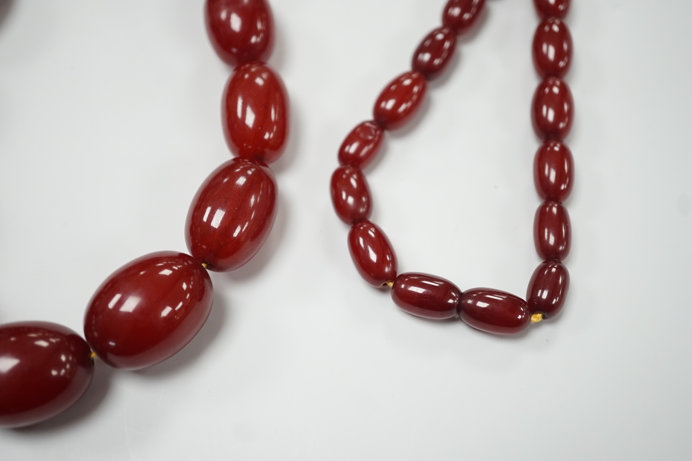 A single strand graduated simulated oval cherry amber necklace, 82cm, gross weight 113 grams.